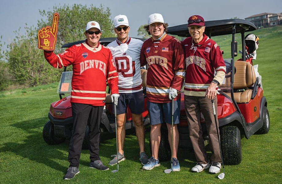 alumni golfers in front of a golf cart
