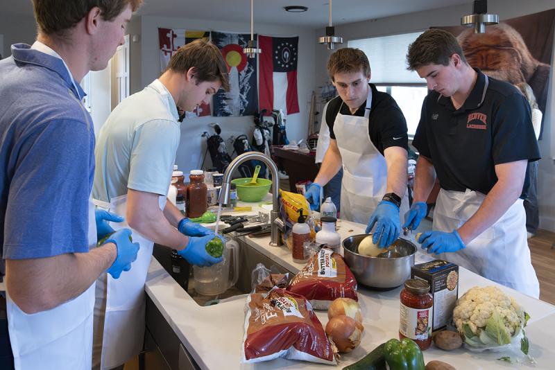 Members of DU's men's lacrosse team prepare meals for Philo's Kitchen.
